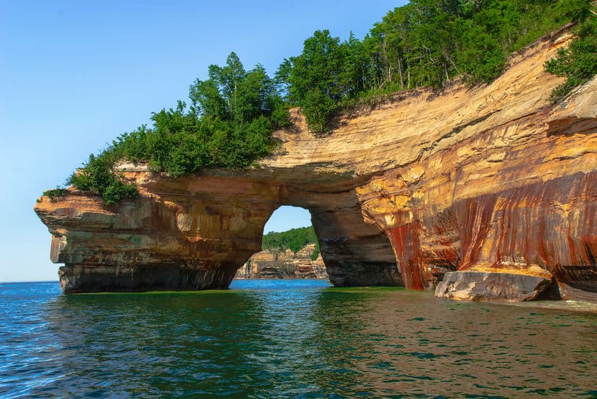 A bridge over a body of water with a mountain in the background. Why You Have To Visit Your Local Parks This Summer