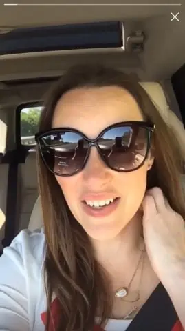 A woman wearing sunglasses taking a selfie in a car. Get a Pair of Sunglasses FREE!