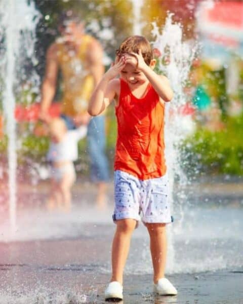 A little boy playing in the water park.