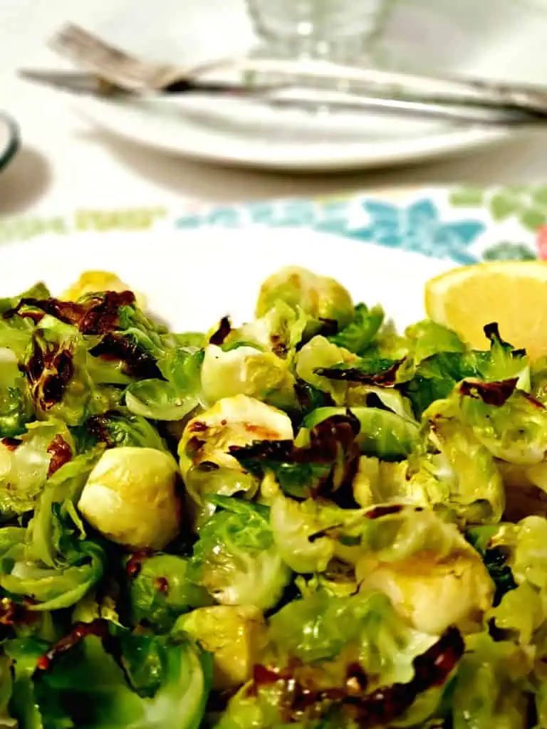 brussel sprouts on white plate with lemon