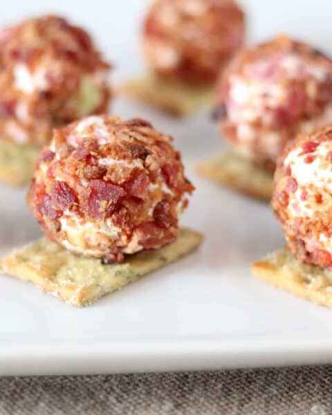 close up of cheeseball bites on white plate