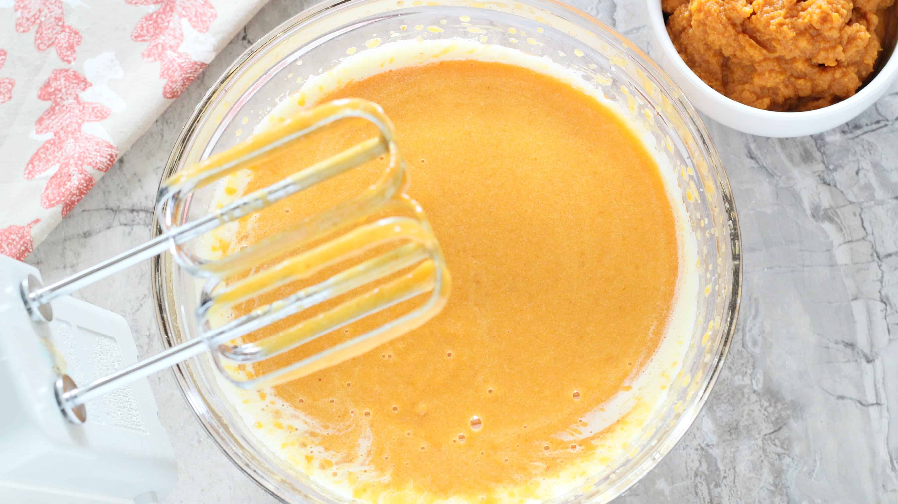 Mix eggs and spices into wet mixtures for Chocolate Chip Pumpkin Cake.