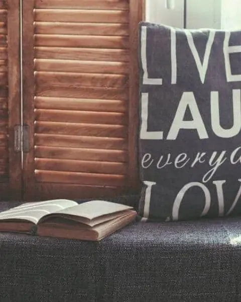 book sitting near a window with a pillow that says live, laugh love everyday