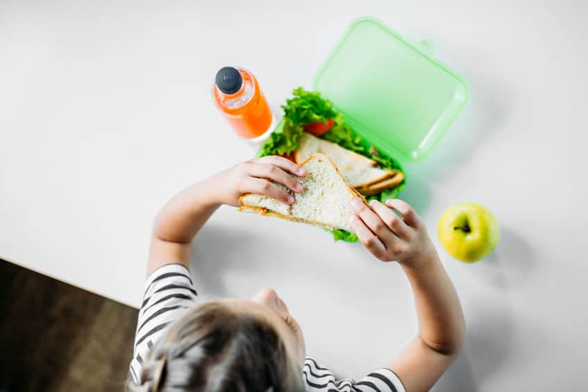 Girl eating a healthy sandwich at school.