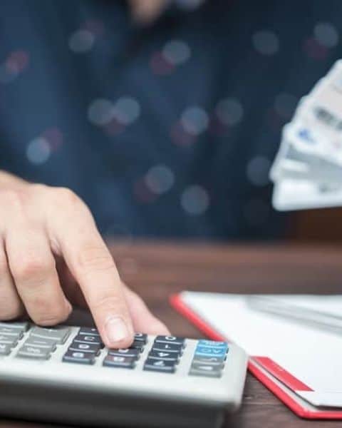 woman paying credit card bills using a calculator