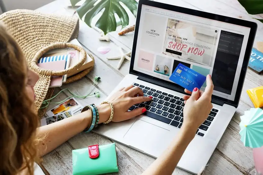 A woman online shopping with a credit card. You can avoid these pitfalls and challenges during your no spend challenge.