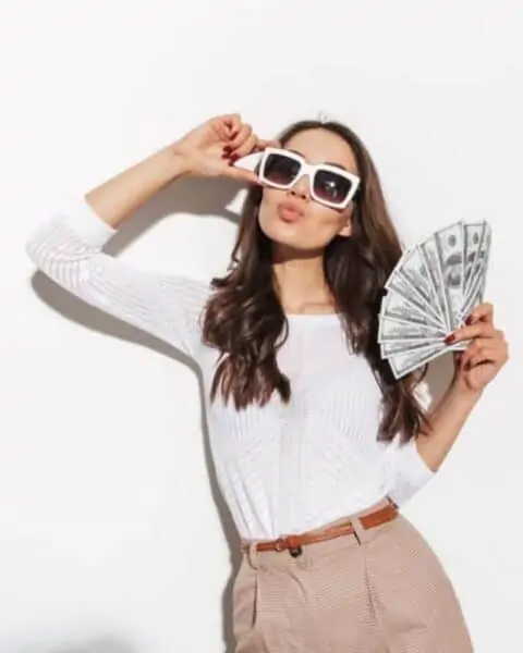 A woman fanning herself with a handful of cash.