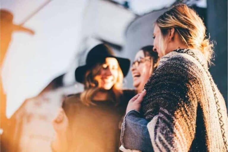 A group of women in winter clothes laughing and talking.