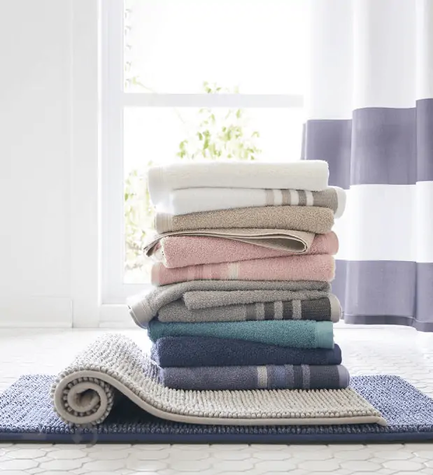 Stack of Home Expressions bath towels in different colors.