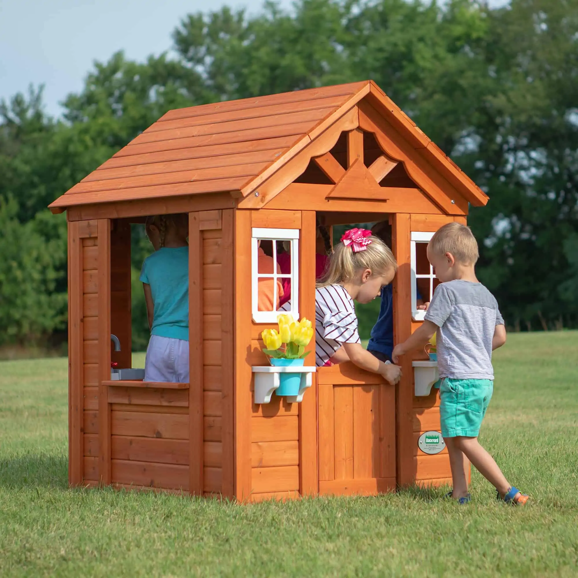 Timberlake cedar wooden playhouse with children playing together.