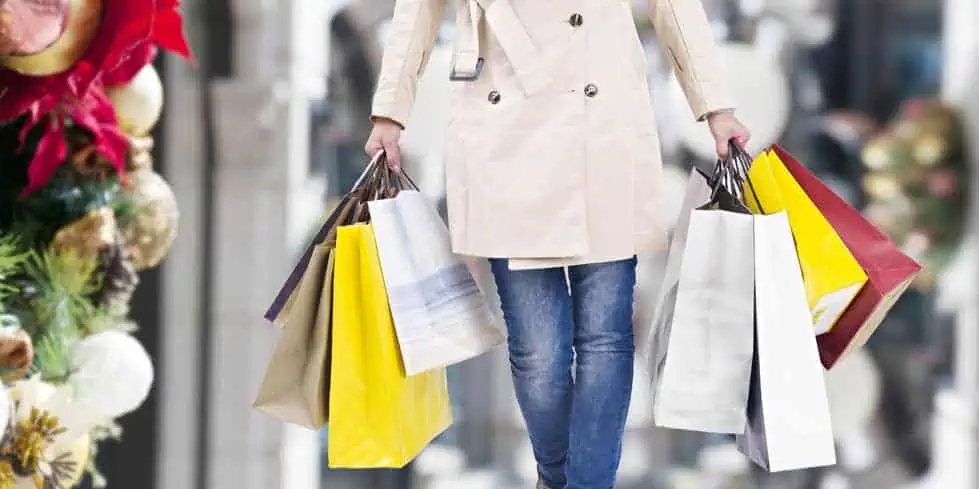woman walking with shopping bags with christmas background.