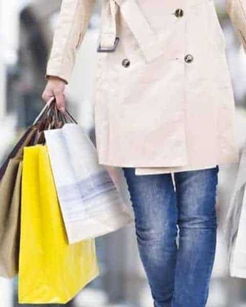 woman holiday shpping with arms full of shopping bags