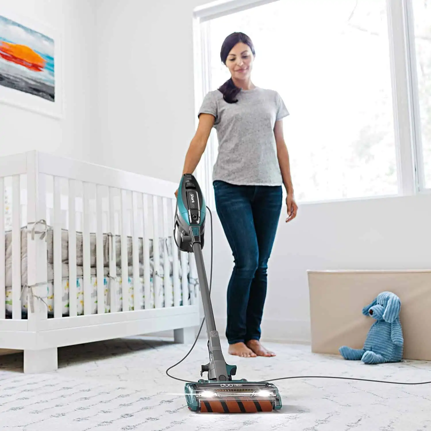A person standing in a room, with Stick Vacuum