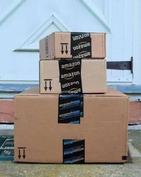 stack of amazon packages on a front porch