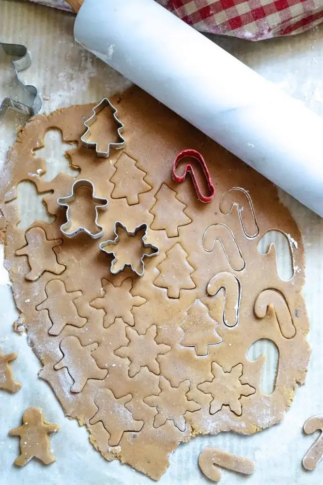 Recipe for Gingersnap Cookies With Frosting, cutting out the shapes of the cookies.