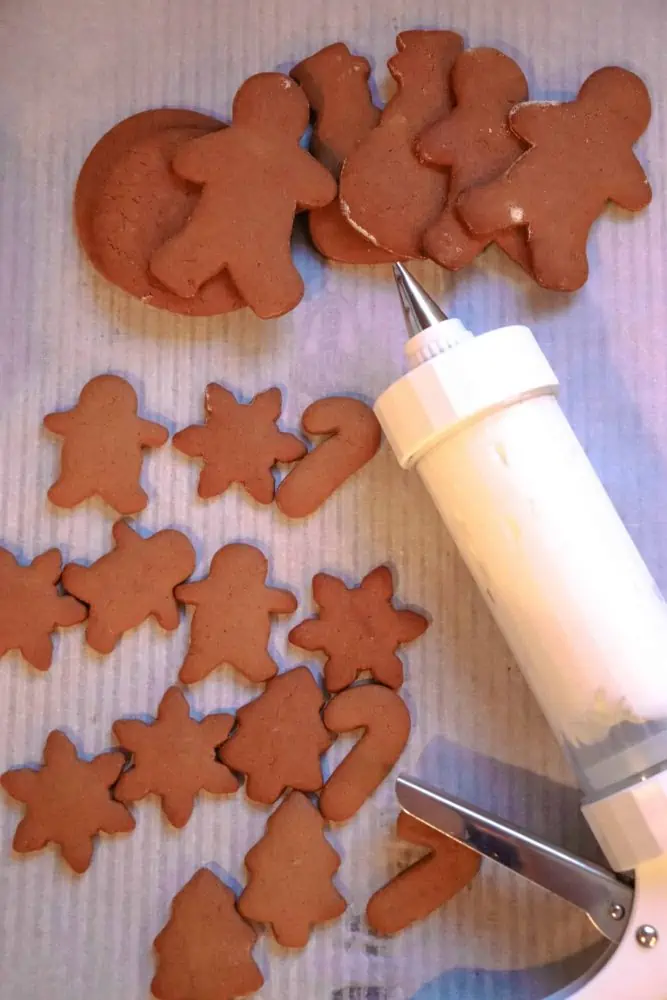 Add frosting to ginger snap cookies.