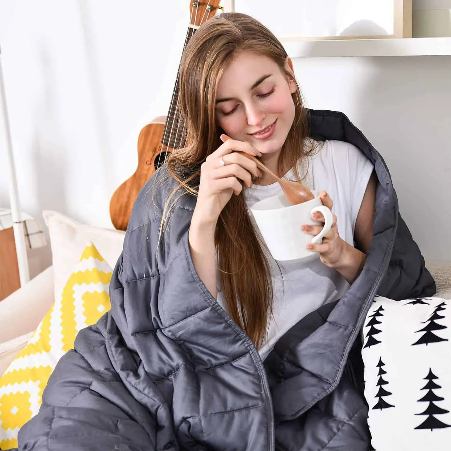 woman eating out of a bowl wrapped in a blanket
