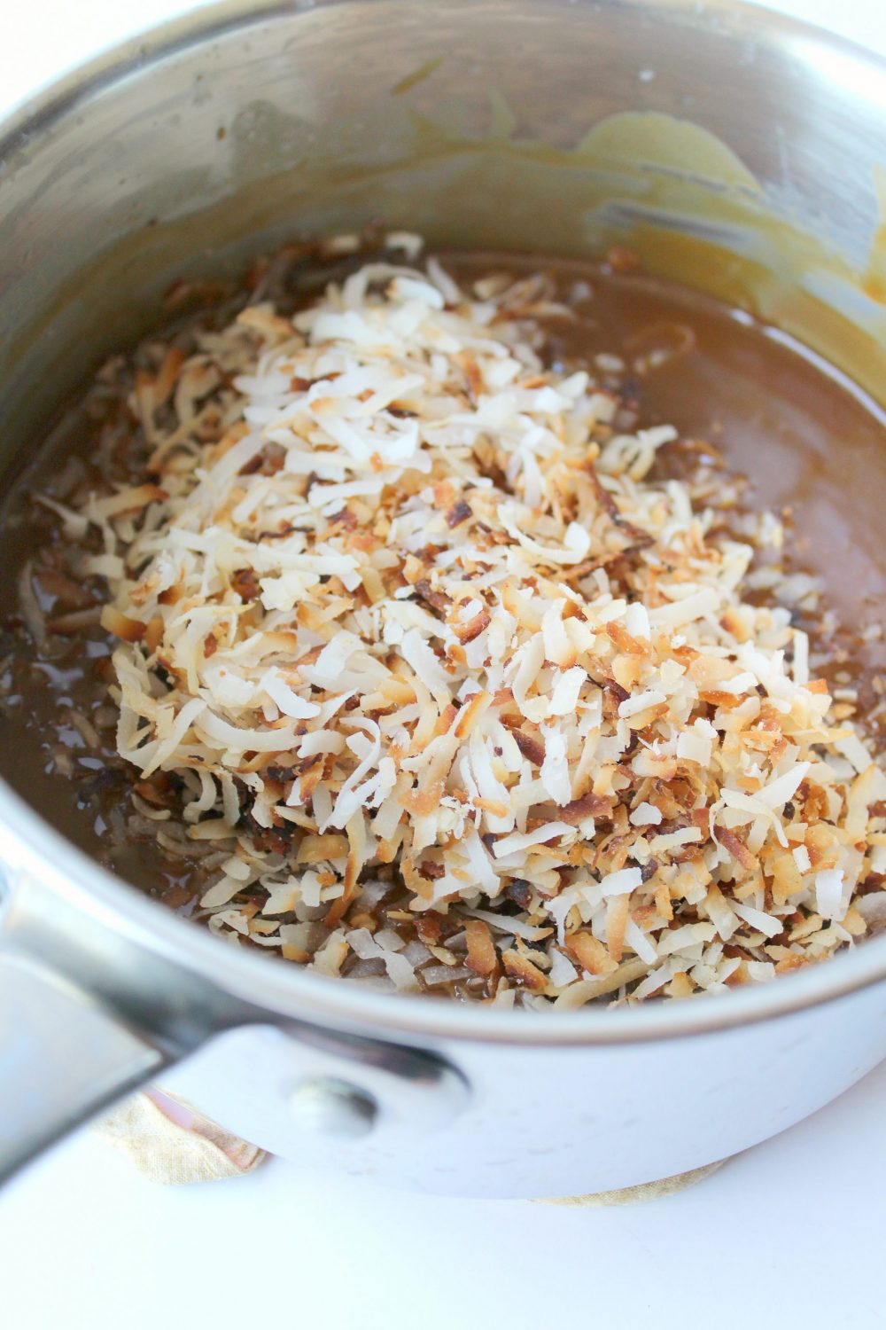 Slowly stir in the toasted coconut and spread over the chocolate-covered crust.