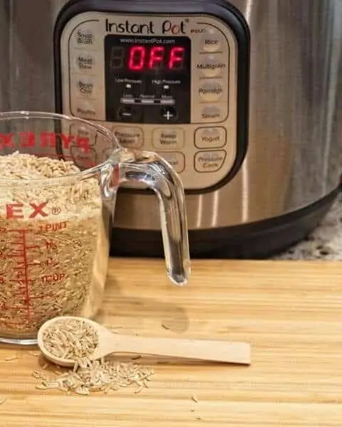 instant pot with a measuring cup of rice on a table