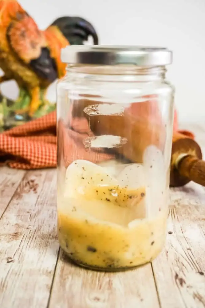 old pickle jar with bacon grease sitting on a table