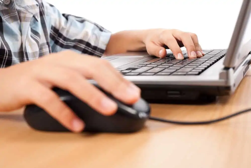 School child working on laptop from Free Educational Resources for Kids Who are Home Due to School Closings