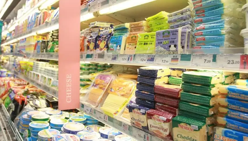 A customer shopping for cheese and other dairy products at a supermarket