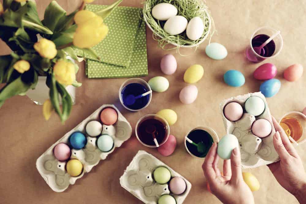 Human hands holding box of dyed eggs