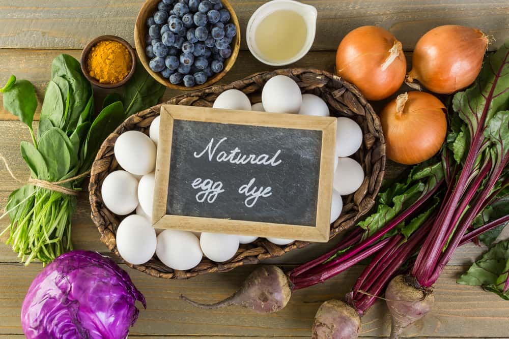 Ingredients for dyeing Easter eggs on a wood table.