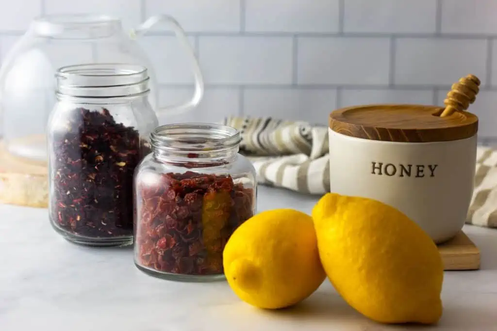 lemon, honey, hibiscus and rosehips on a table. 