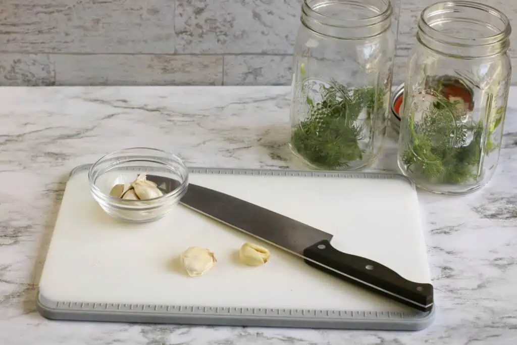 Garlic cloves cut on a cutting board with a sharp knife.