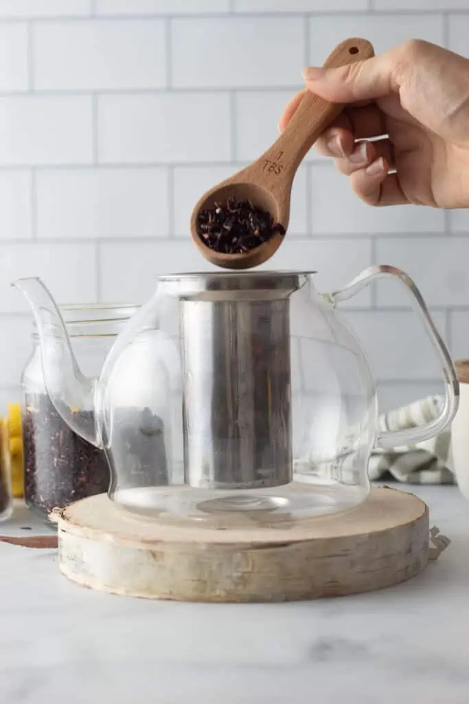 Add hibiscus and  rosehips to a tea strainer and pour into tea pot.