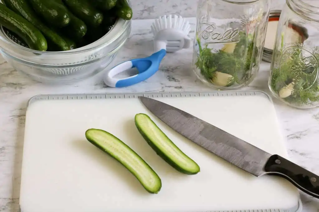 Long sliced cucumbers on a cutting board.