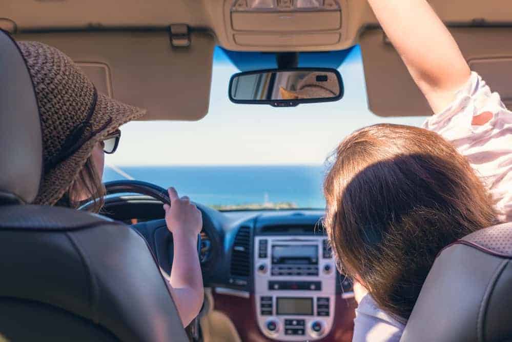 Two girls traveling by car on the Italy. One of them is looking map