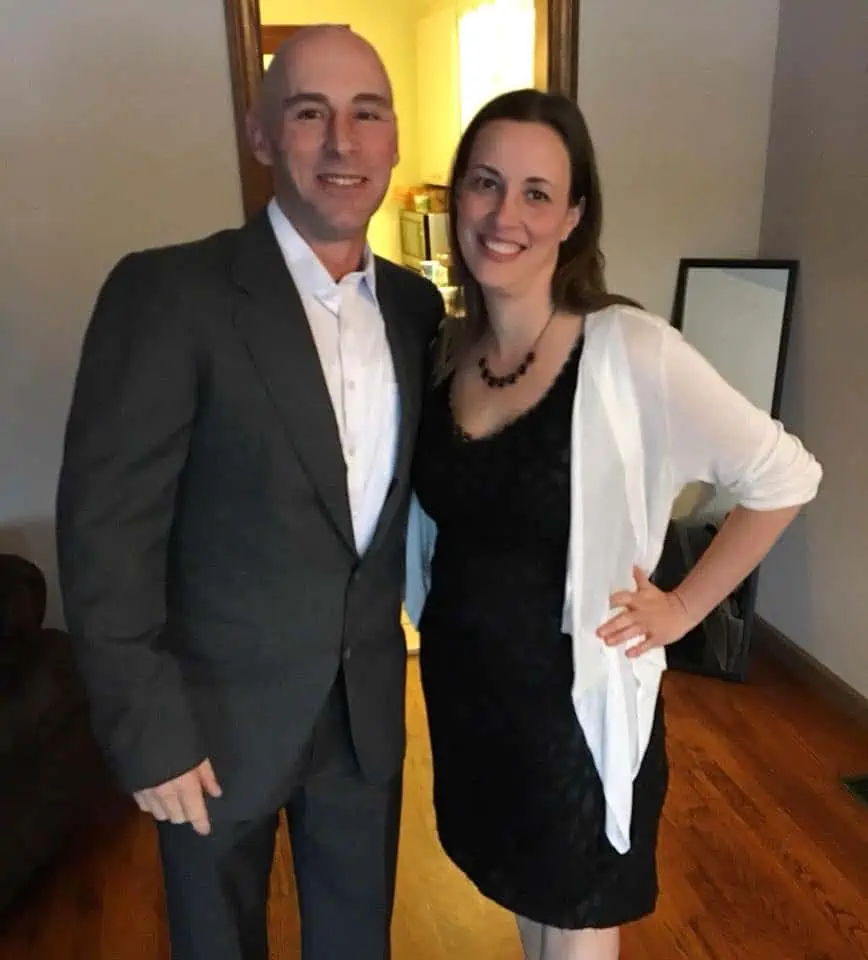 A smiling couple dressed in fancy clothes for a happy evening out.