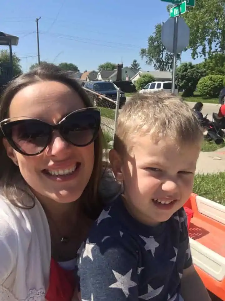 A smiling woman with a little boy on her lap.