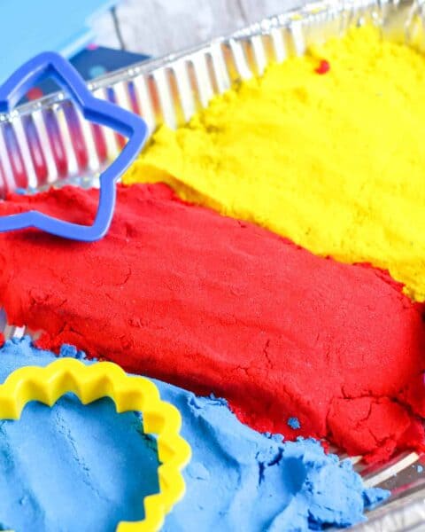 Kinetic sand with plastic cookie cutters.