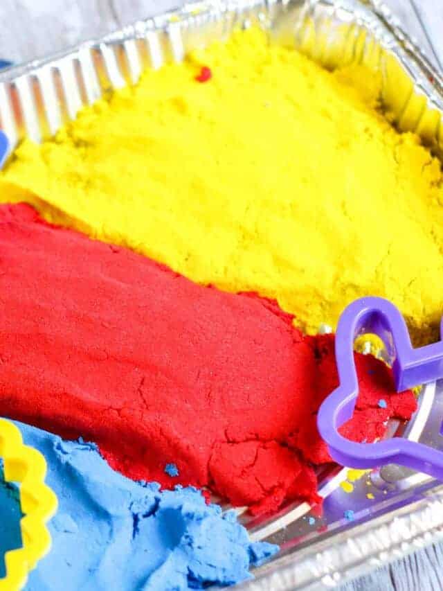 A tin of blue, red, and yellow kinetic sand.