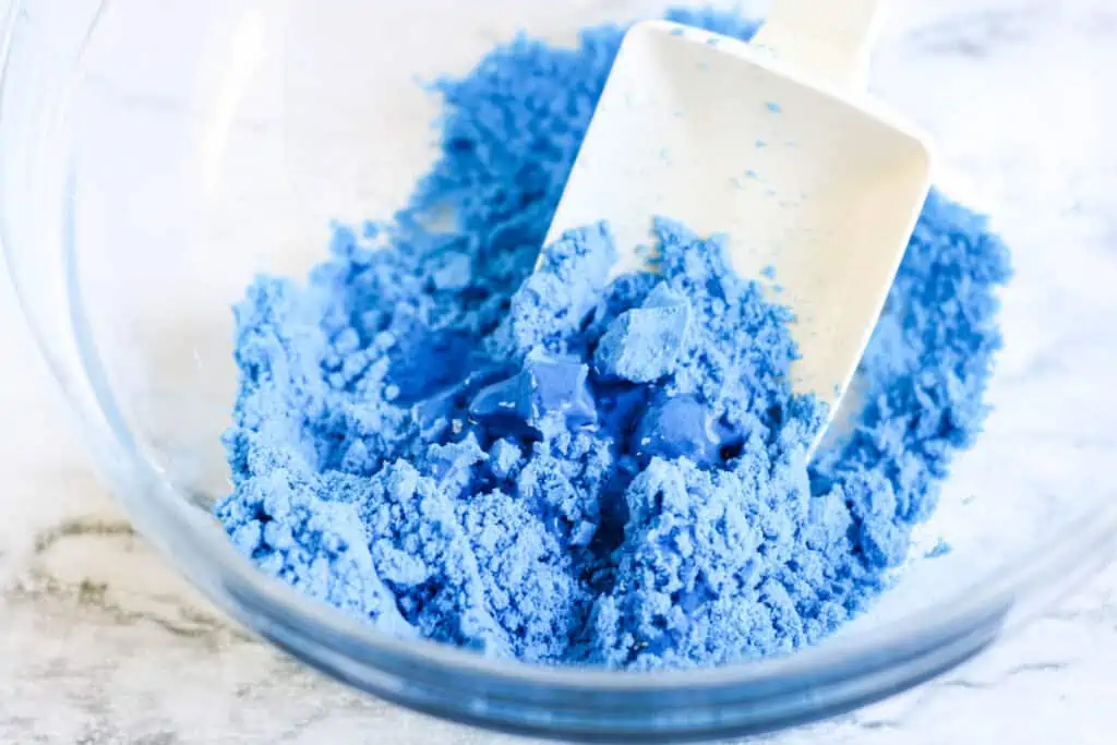 Add glue and stir to make Homemade Kinetic Sand Recipe.