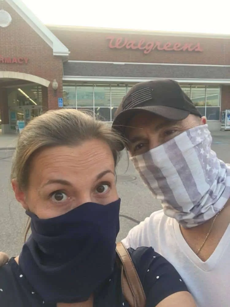 Man and woman wearing face masks and shopping outside of Walgreens.