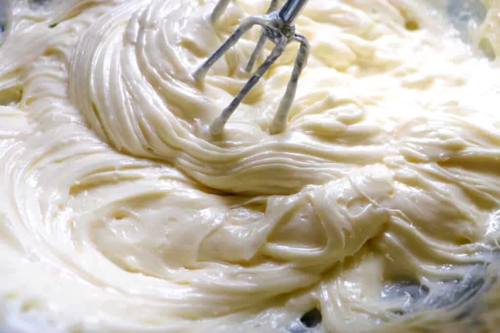 a bowl full of creamy homemade cream cheese frosting.