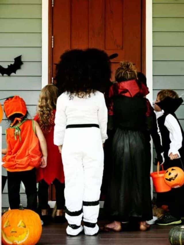 A group of kids dressed for Halloween going trick or treating.