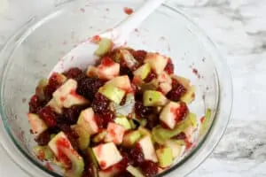 Ingredients mixed for an apple cranberry walnut salad.