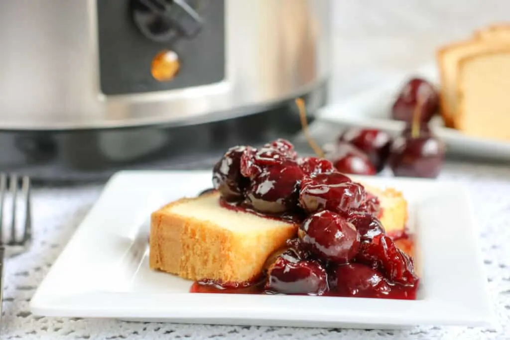 A thick and creamy cherry jubilee on a white square plate.