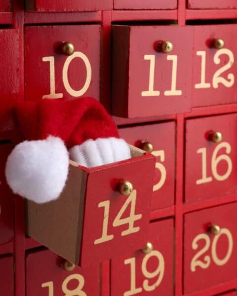 Christmas advent calendar with a little Santa hat coming out of box 14.