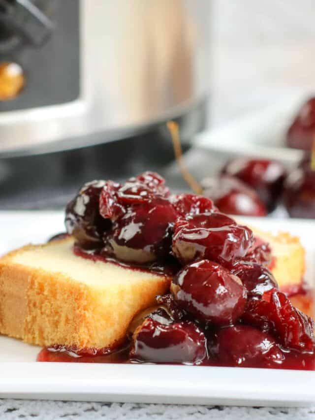 Canned cherries on top of a slice of shortbread.