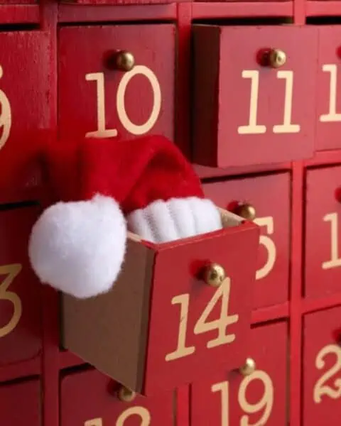 Christmas advent calendar with a little Santa hat coming out of box 14.