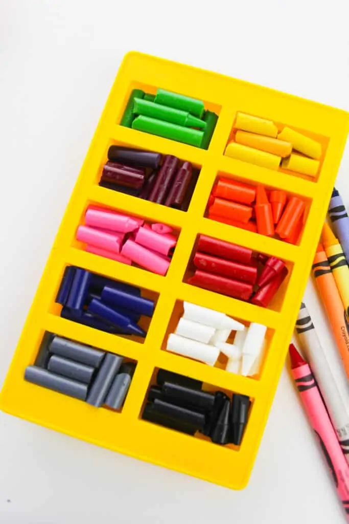Broken crayon pieces in silicone mold and organized by color.