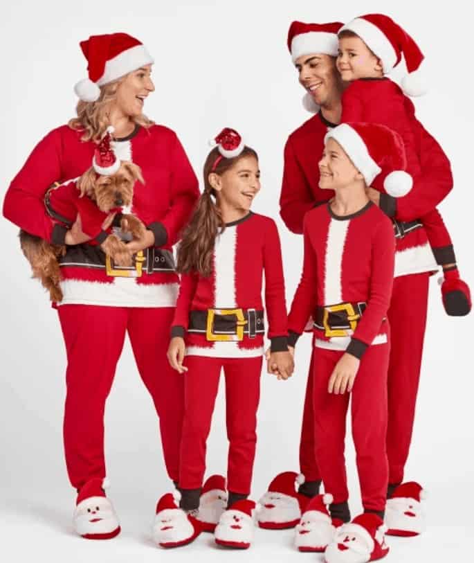 A family wearing Christmas pajamas that look like Santa Claus pajamas.