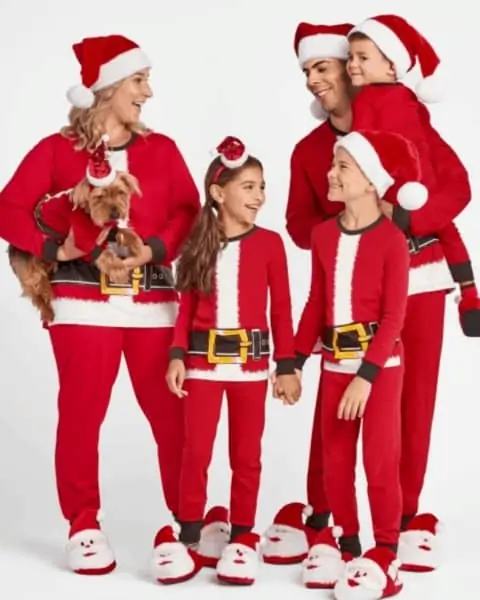 A family wearing Christmas pajamas that look like Santa Claus pajamas.