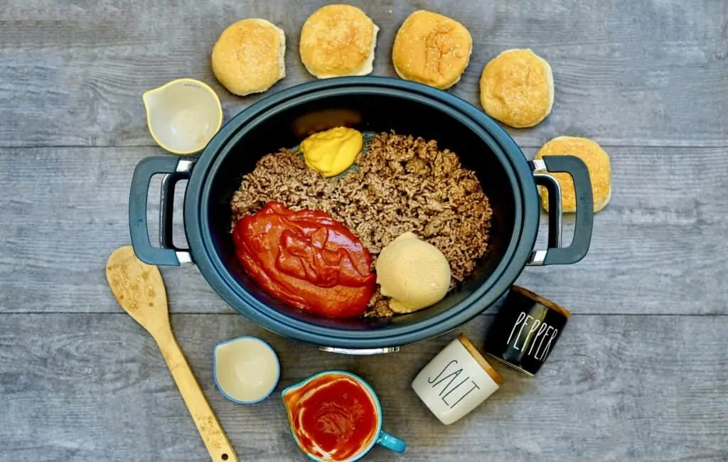 Sloppy joe meat with other toppings placed in slow cooker to be cooked. 